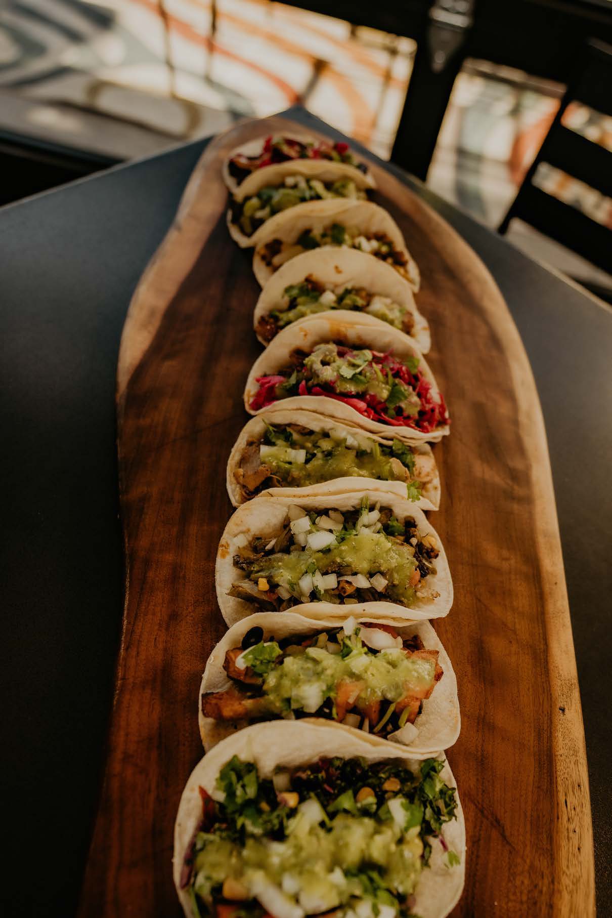 Row of tacos on a wooden board